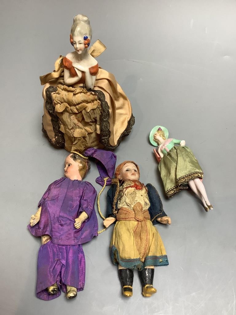 Two small bisque head dolls, height 13cm, and two porcelain head pin cushion ladies